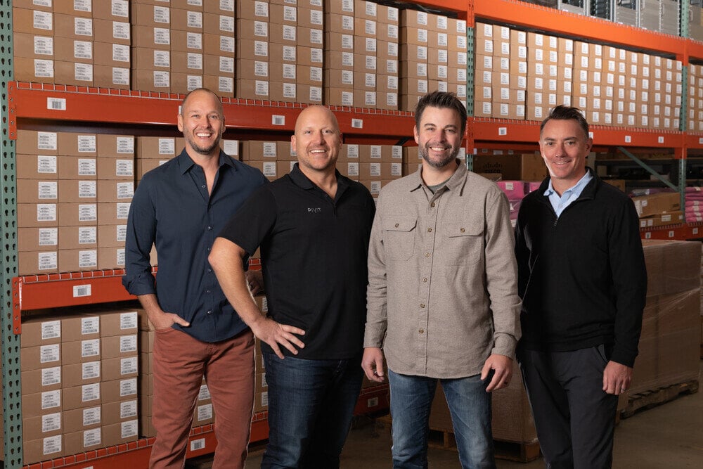 Four Partners in front of shelves